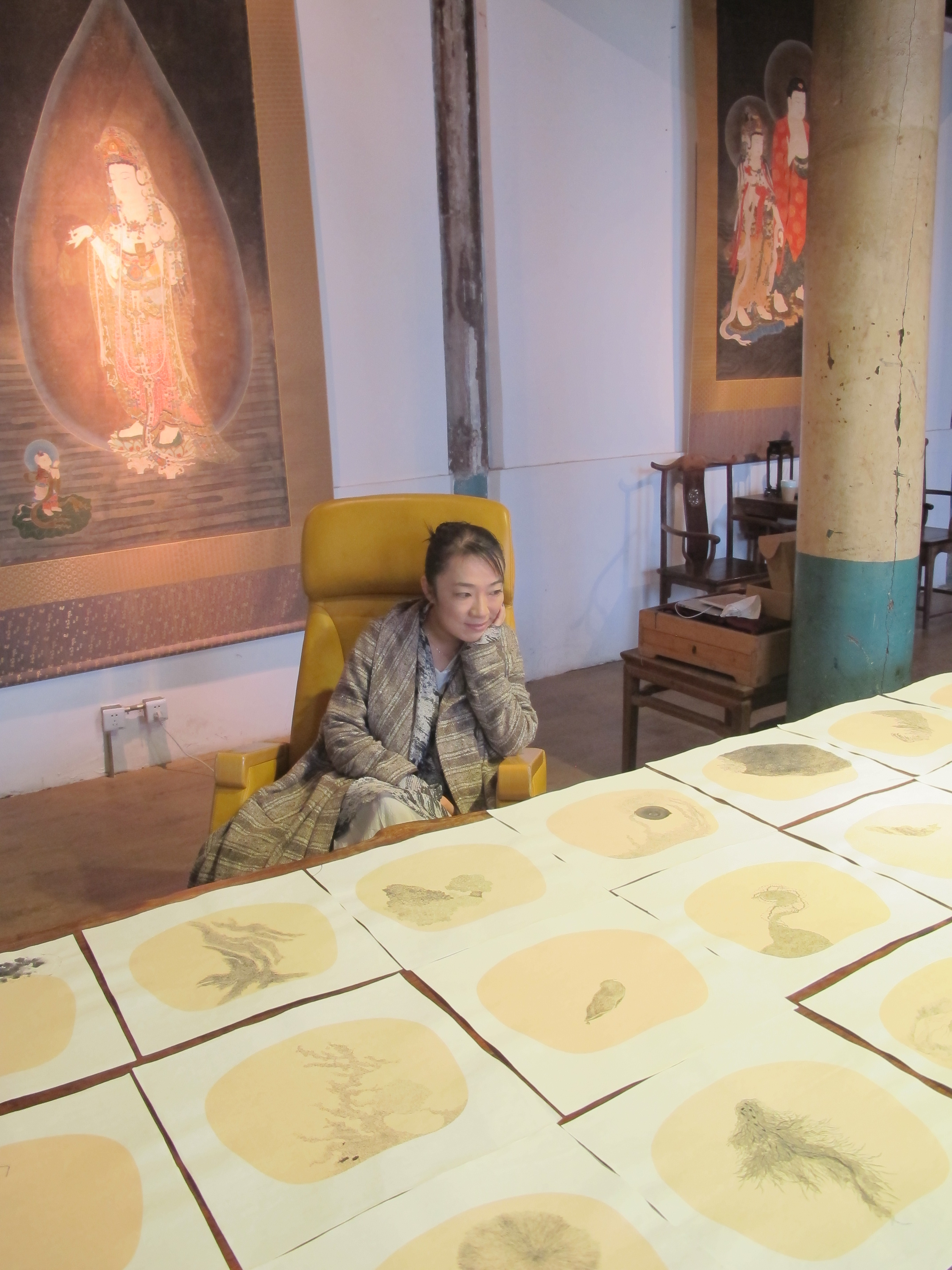 Bingyi in her studio, Beijing, 2013, with her ink on paper works, photograph Luise Guest